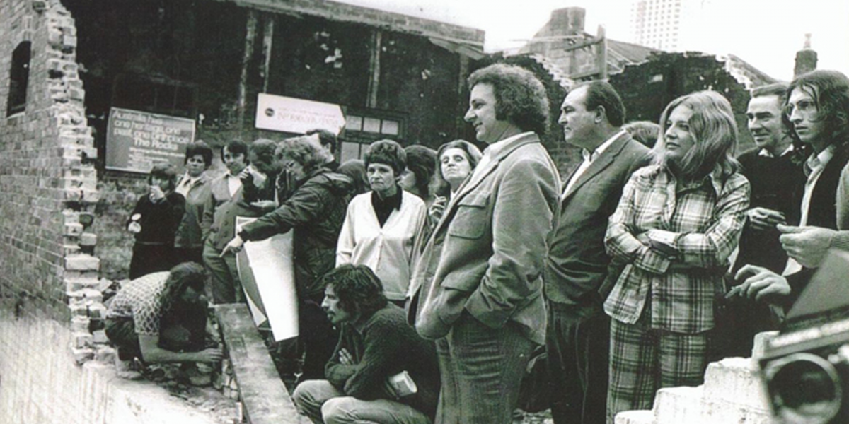 group of people standing, broken wall