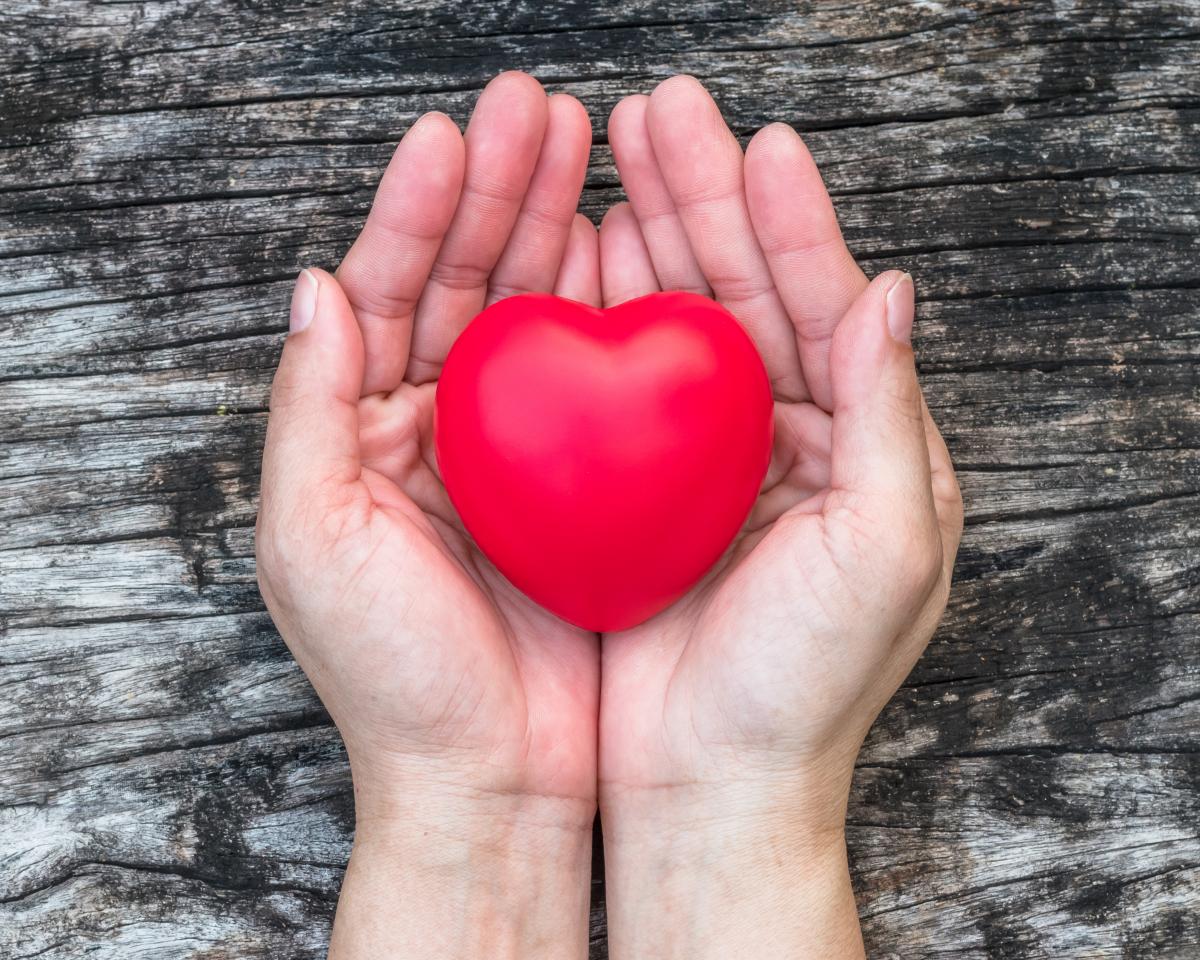 phot of hands handing a red heart shape
