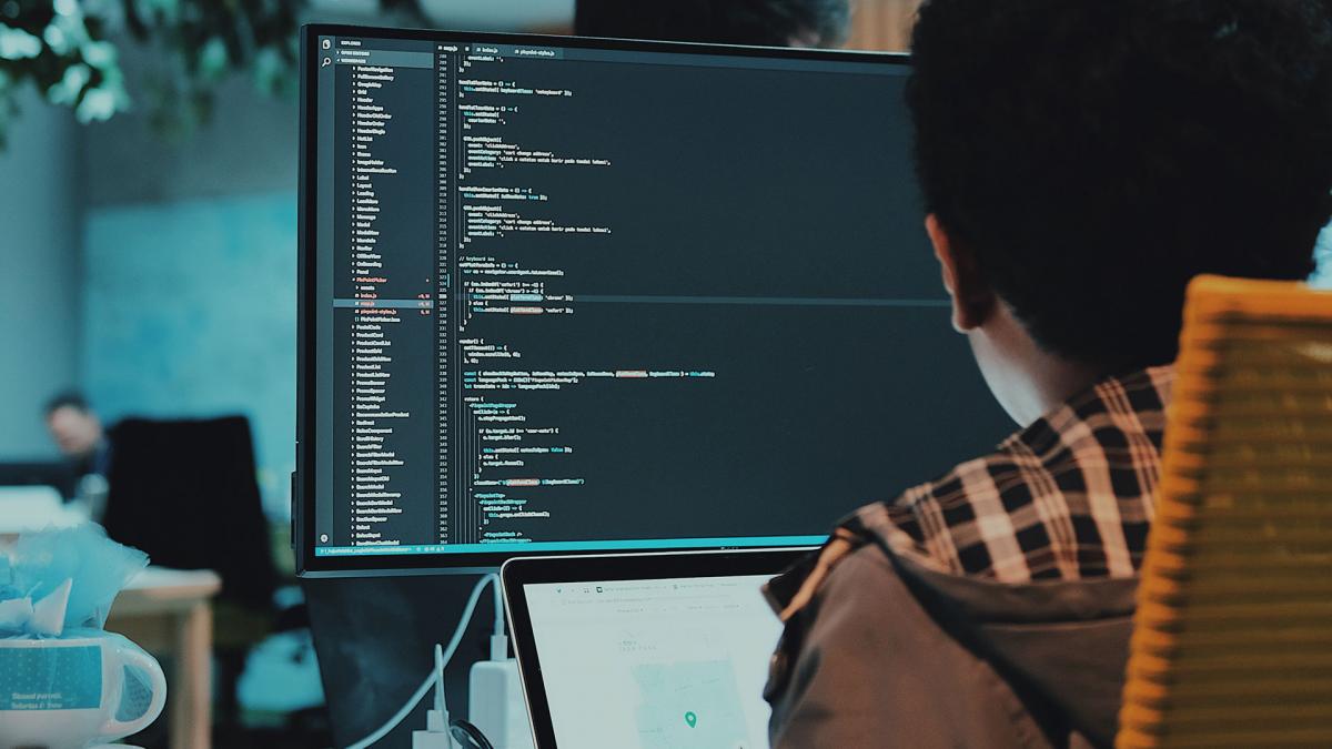 Person sitting at a computer writing code