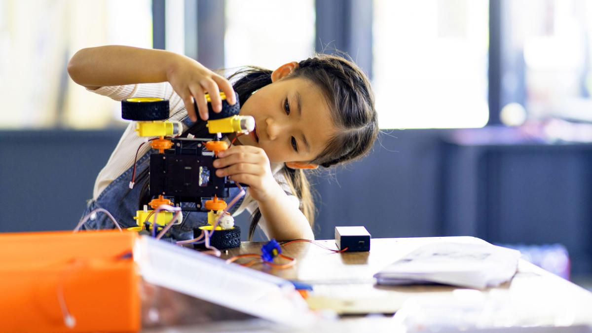 Young girl building a robot