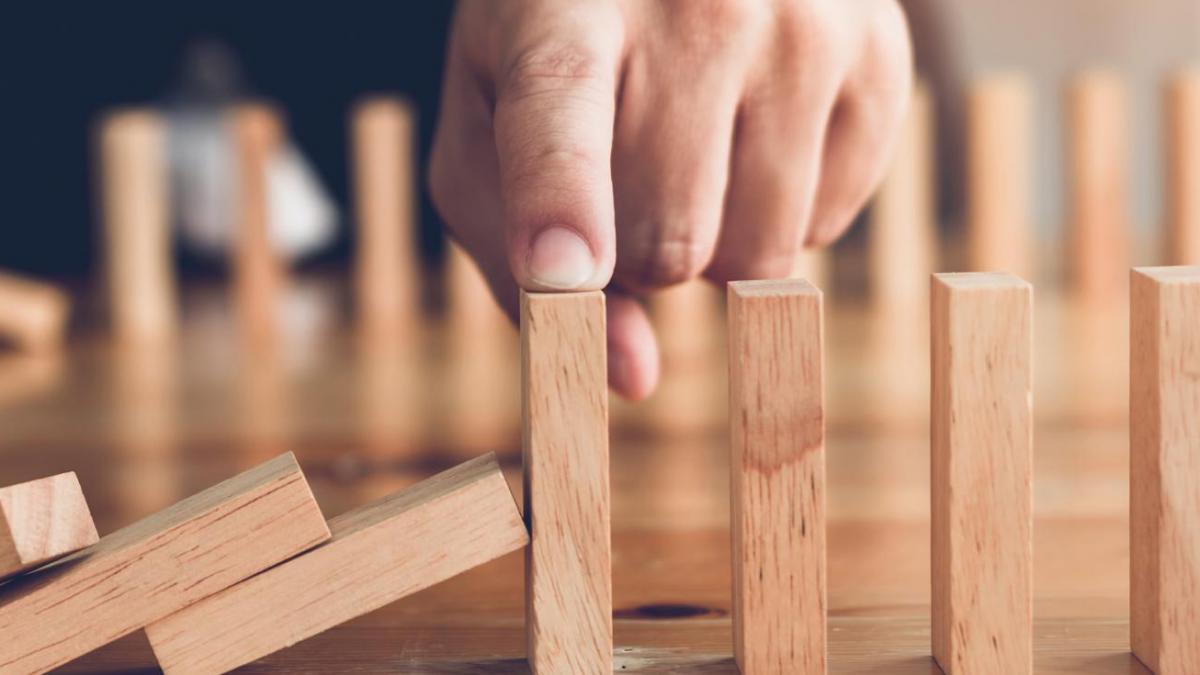 photo of a hand stopping falling rods on a table