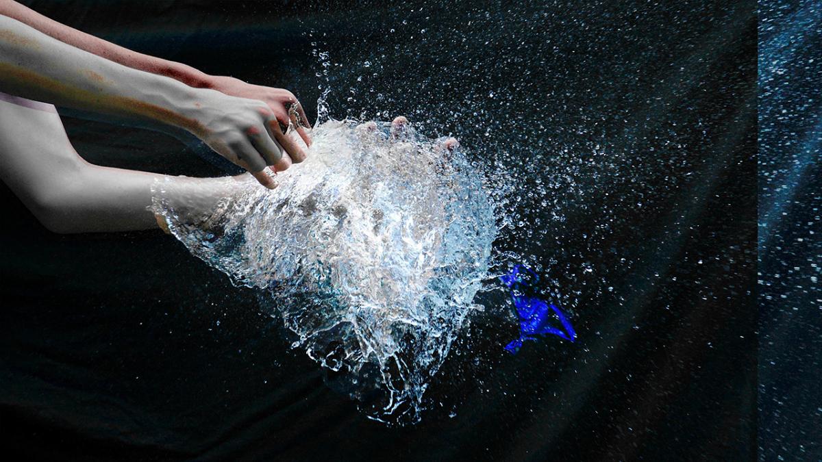 hands popping a water balloon