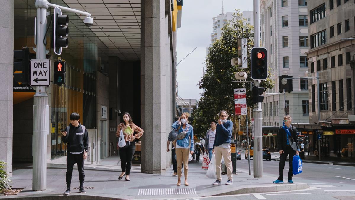 photo of people on city street wearing face masks