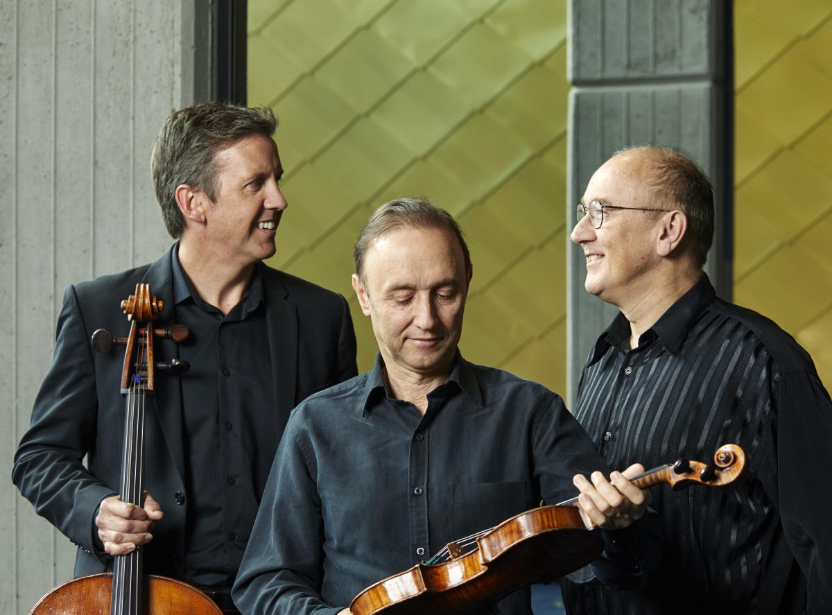 Musicians in front of gold wall